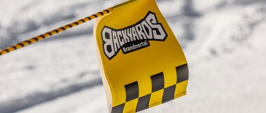 Ein Wimpel vom Backyards Brandnertal flattert im Wind. | © Bergbahnen Brandnertal, Roman Nöstler