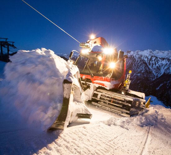 Der Kässbohrer mit Winde hängt am Windenseil und schiebt Schnee im Schild nach oben. | © Bergbahnen Brandnertal, Michael Marte