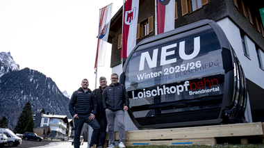 Die neue 10er Gondel der Loischkopfbahn steht vor dem Gemeindezentrum Bürserberg. Die Bürgermeister der Dörfer Brand und Bürserberg und der Geschäftsführer der Bergbahnen Brandnertal stehen vor der Gondel. | © Bergbahnen Brandnertal, Viviane Seils