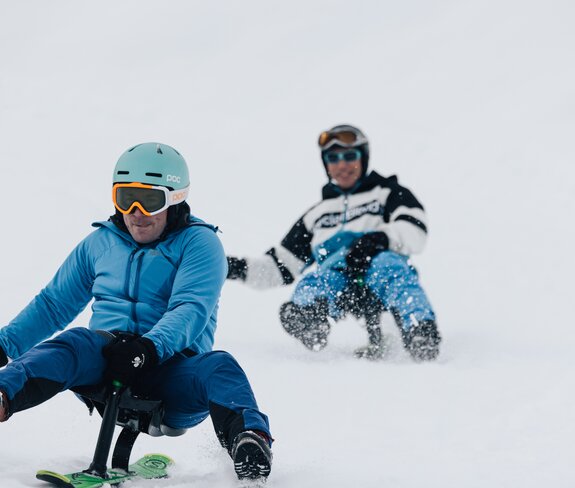 Ein Rodler im Vordergrund rodelt konzentriert auf dem Snooc während ihn ein anderer Rodler verfolgt. | © Bergbahnen Brandnertal, Timo Hummel