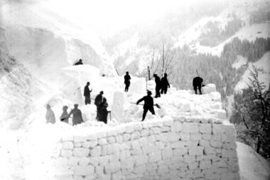 Männer der Lehnenpartie bei der Errichtung eines Schneedamms